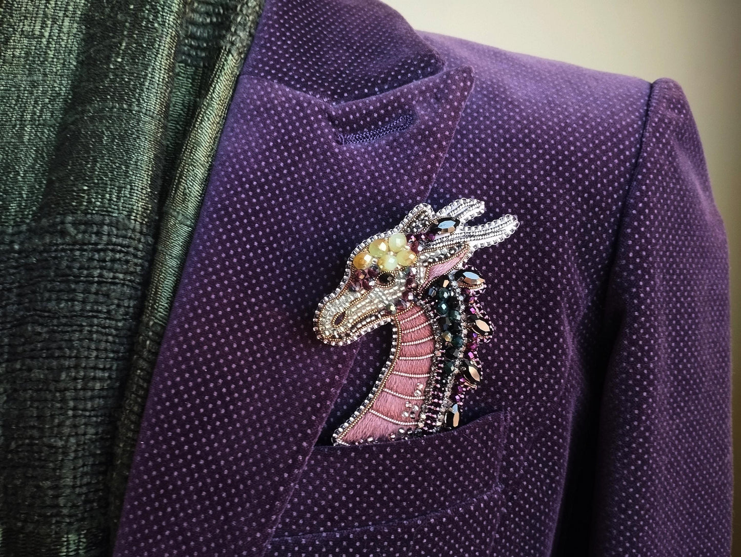 A purple velvet jacket with a decorative dragon brooch pinned to the lapel.