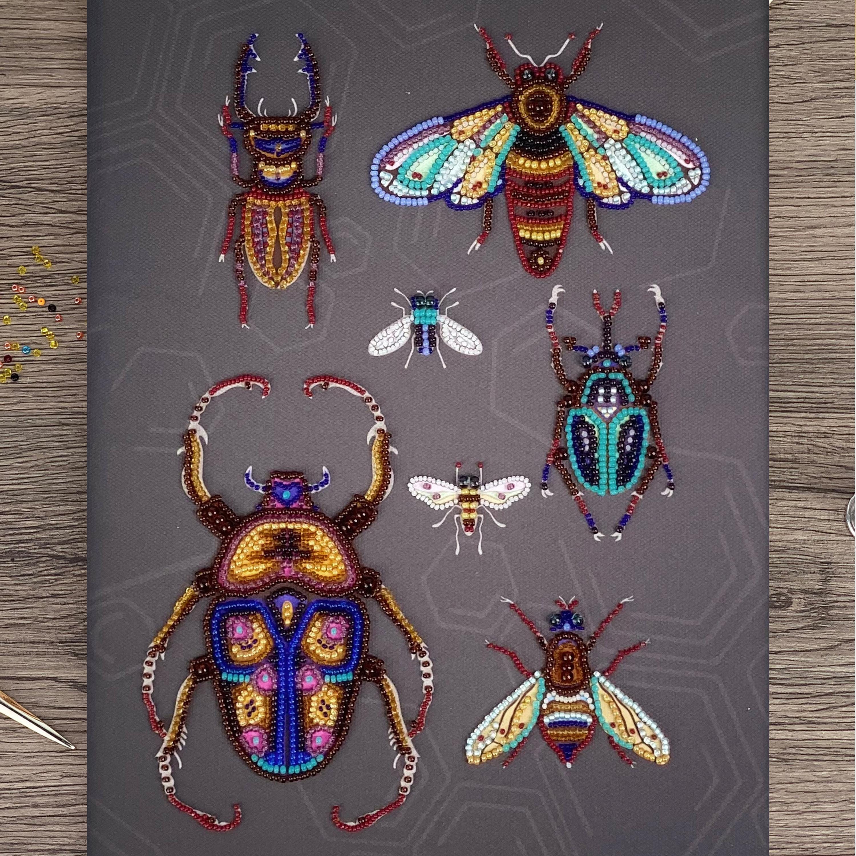 a collection of six intricately designed, colorful, and detailed insects, including a large dragonfly, a bee, a butterfly, a ladybug, a praying mantis, and a grasshopper, all crafted from beads.