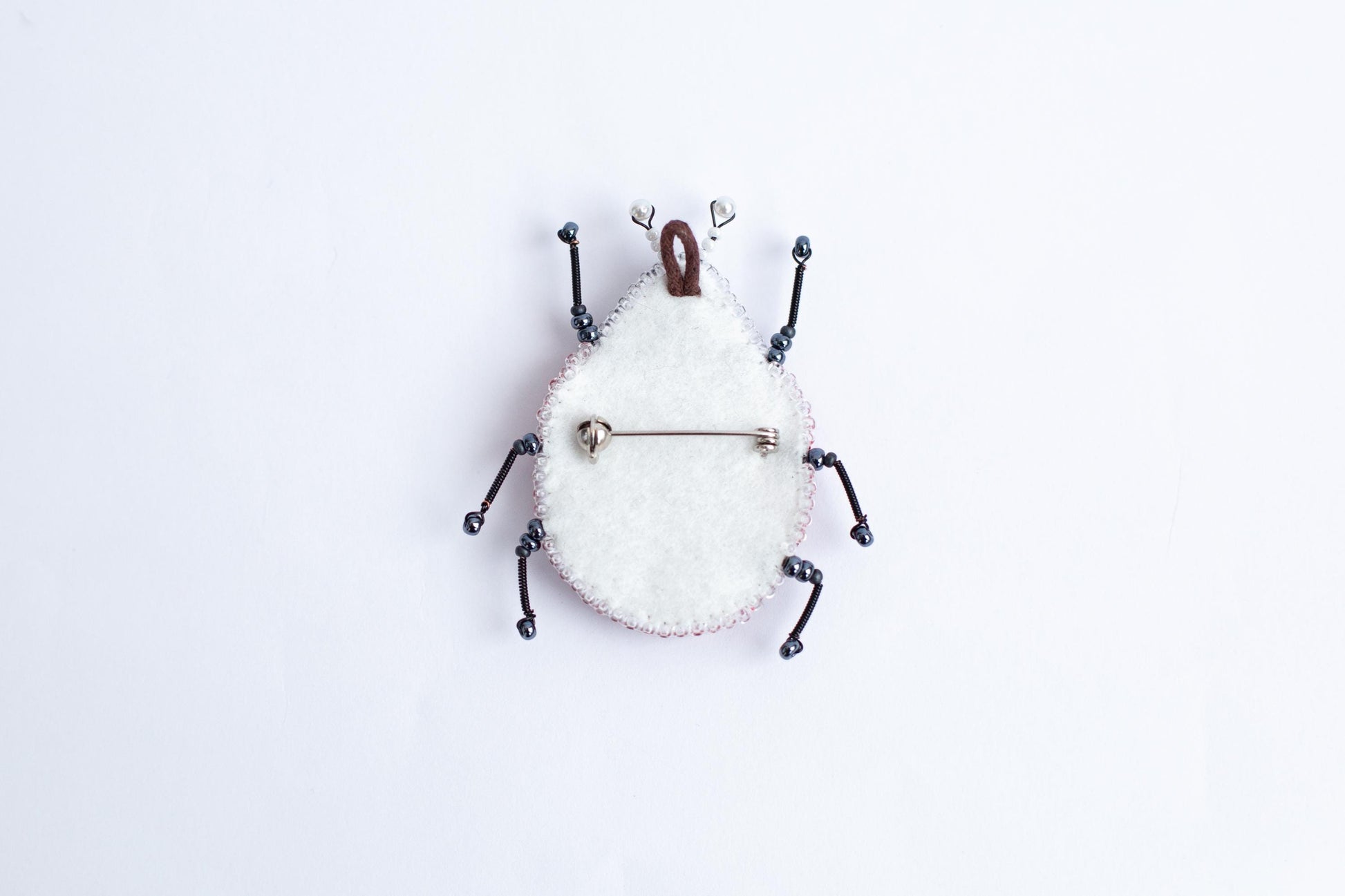 a white clock with a bug on it&#39;s face