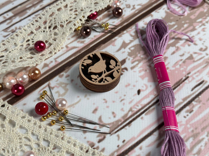 a pair of scissors, a thread, and some beads on a table