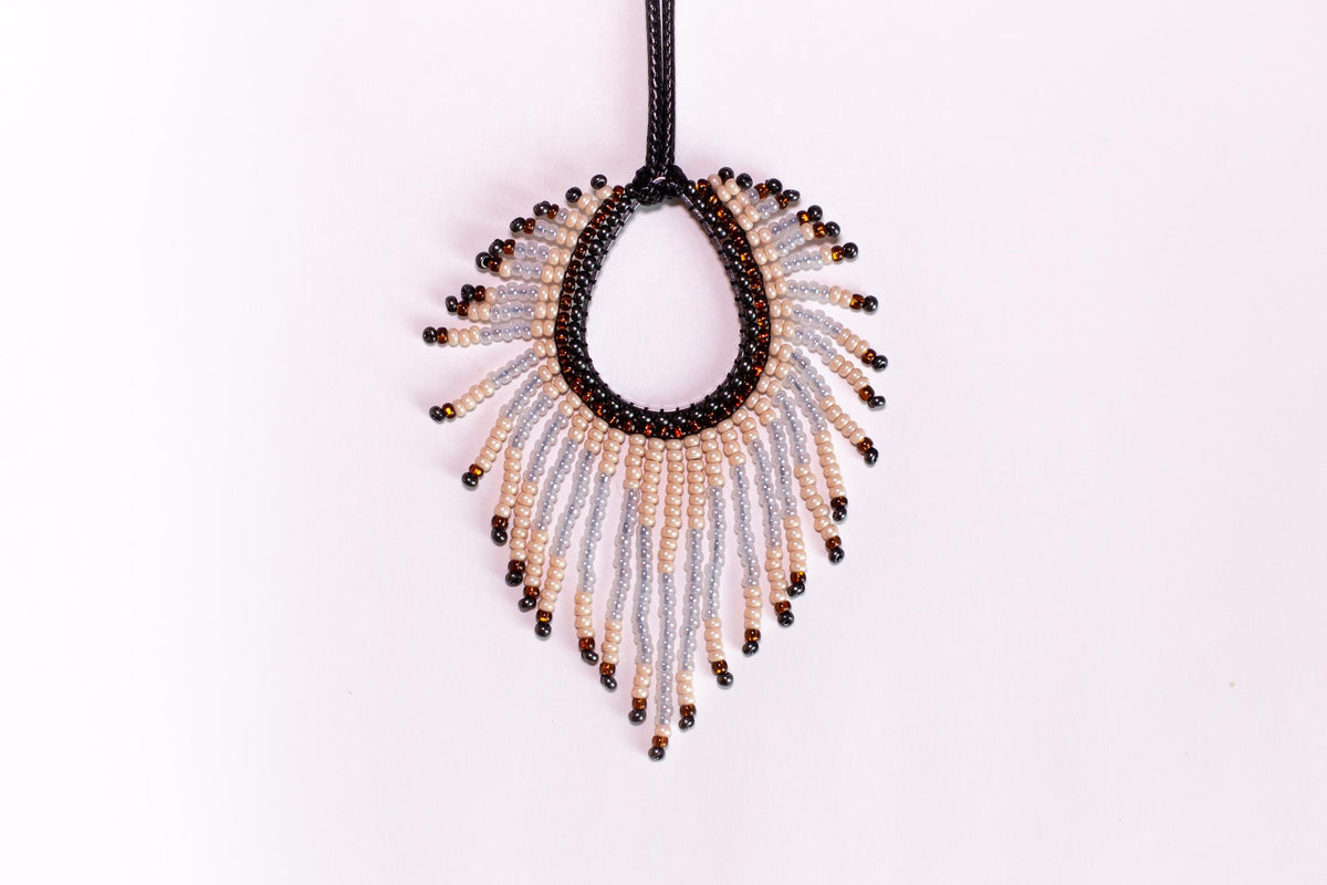 a beaded necklace hanging from a black cord