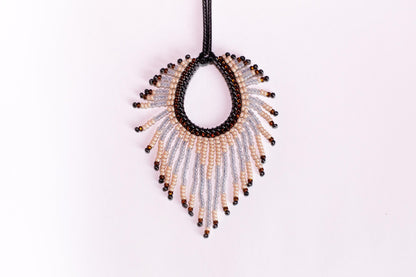 a beaded necklace hanging from a black cord