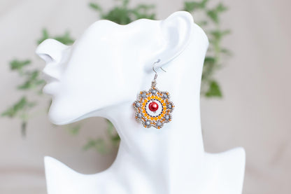 a close up of a pair of earrings on a mannequin head