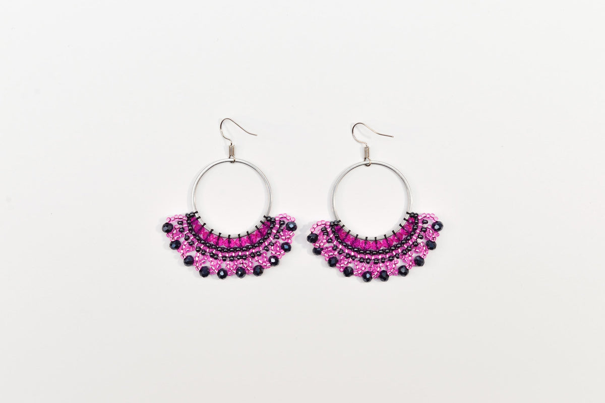 A pair of earrings with a circular design and a row of small, colorful beads or stones.
