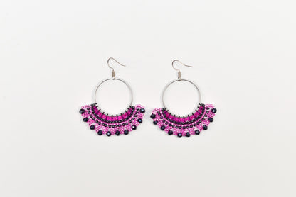 A pair of earrings with a circular design and a row of small, colorful beads or stones.