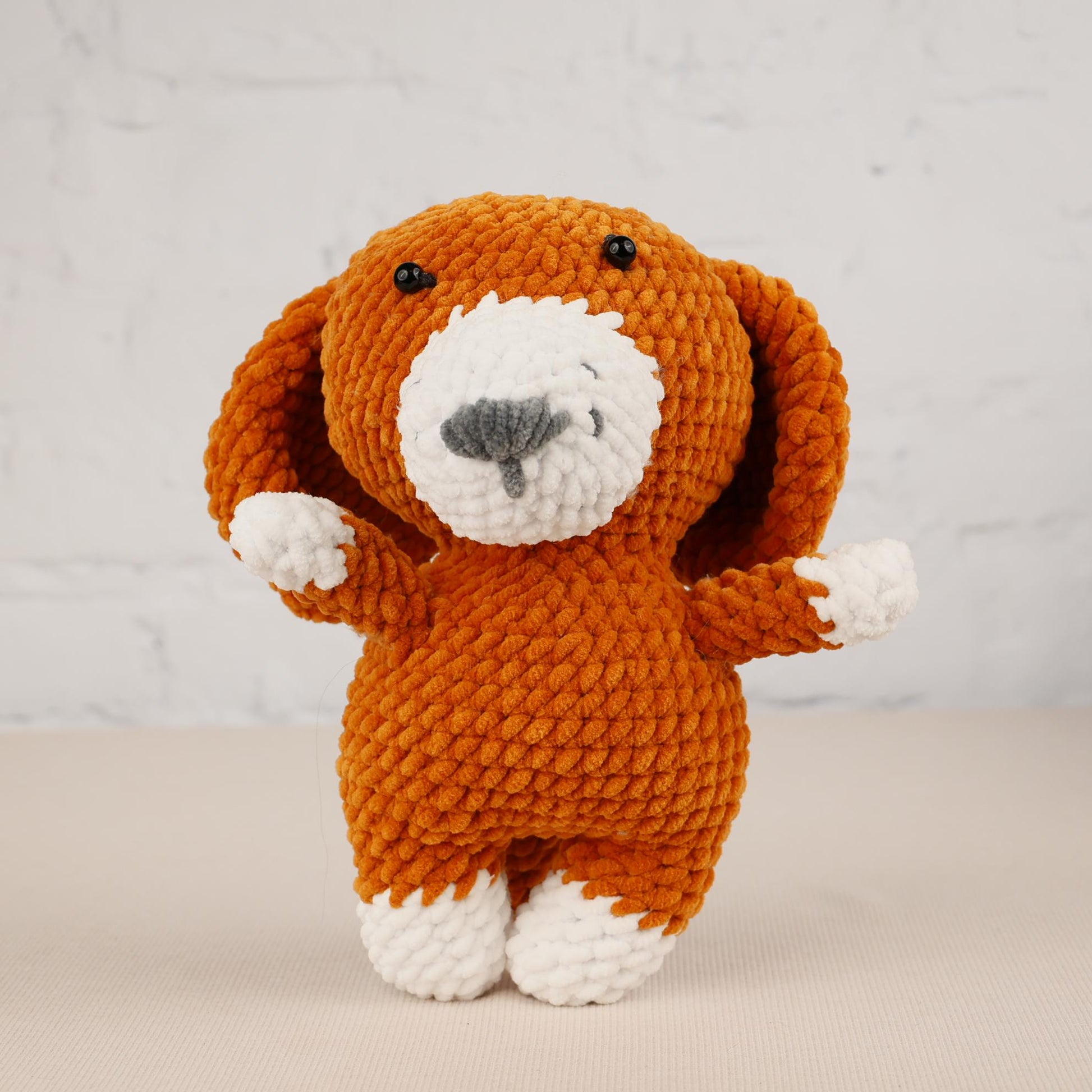 a knitted dog is standing on its hind legs