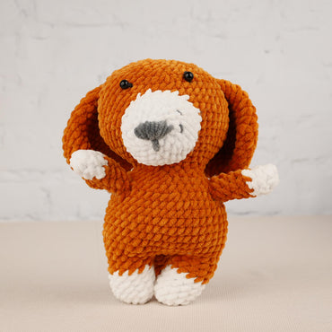a knitted dog is standing on its hind legs
