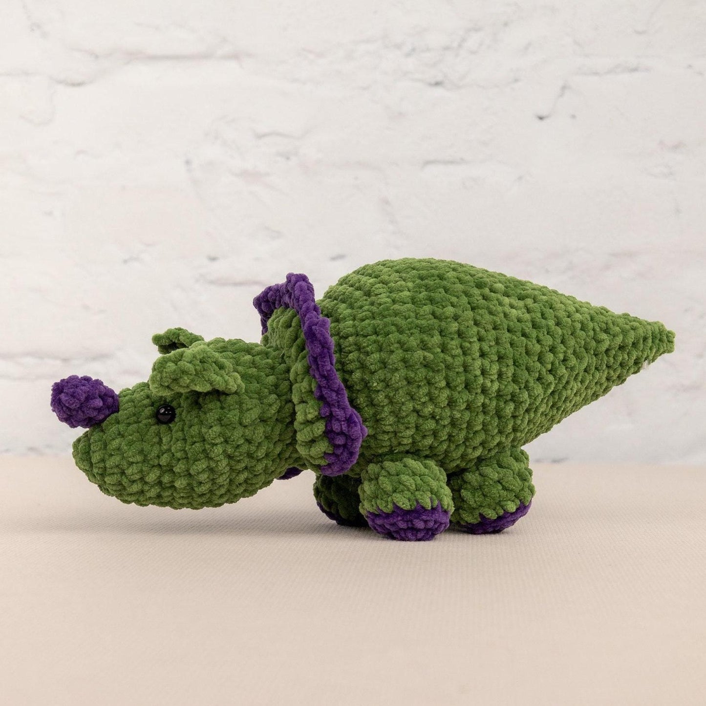 a crocheted green and purple stuffed animal