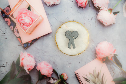 a small key on a piece of cake surrounded by pink flowers