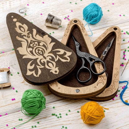 a pair of scissors sitting on top of a wooden cutting board