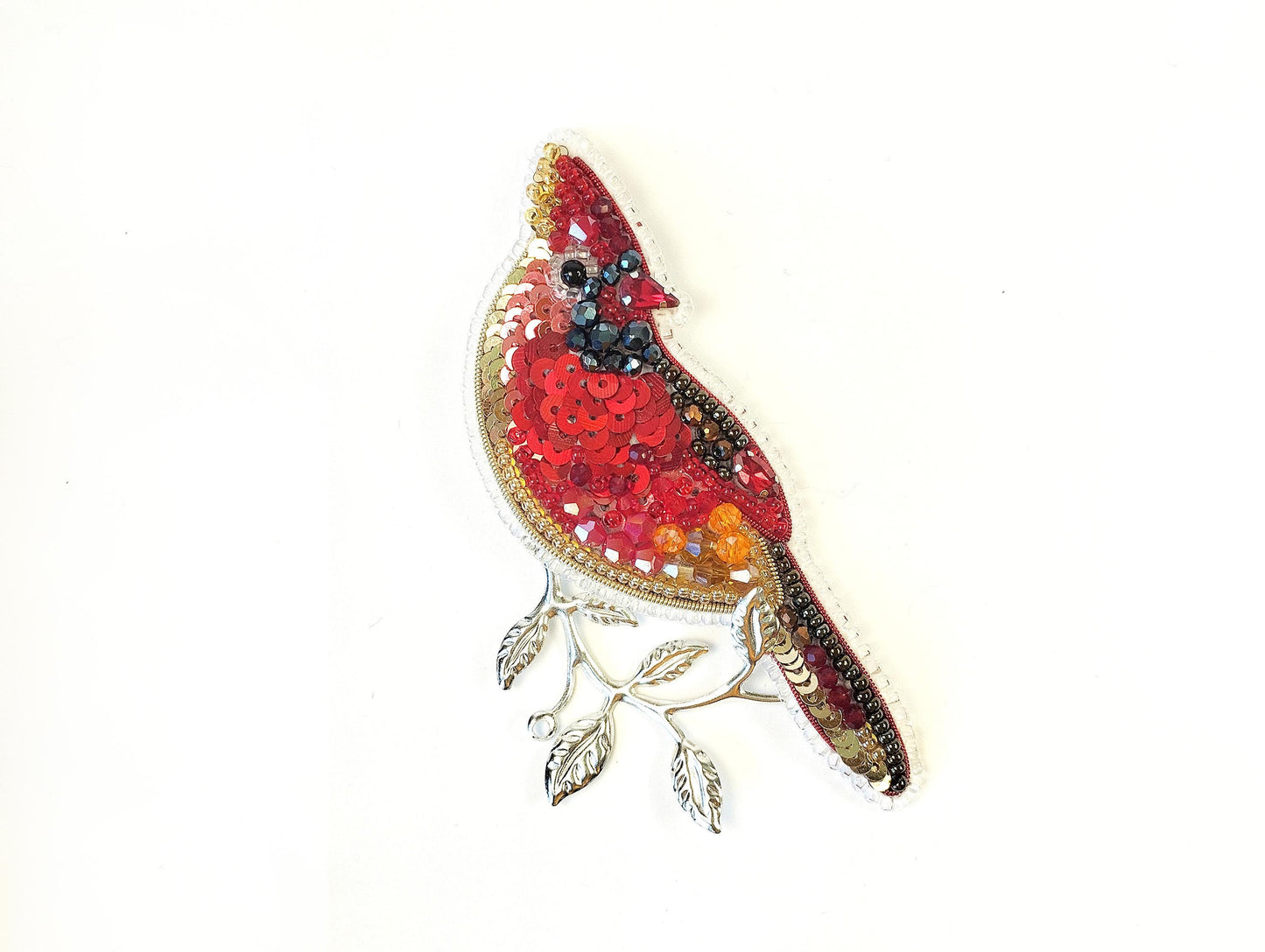 a red bird sitting on top of a white wall