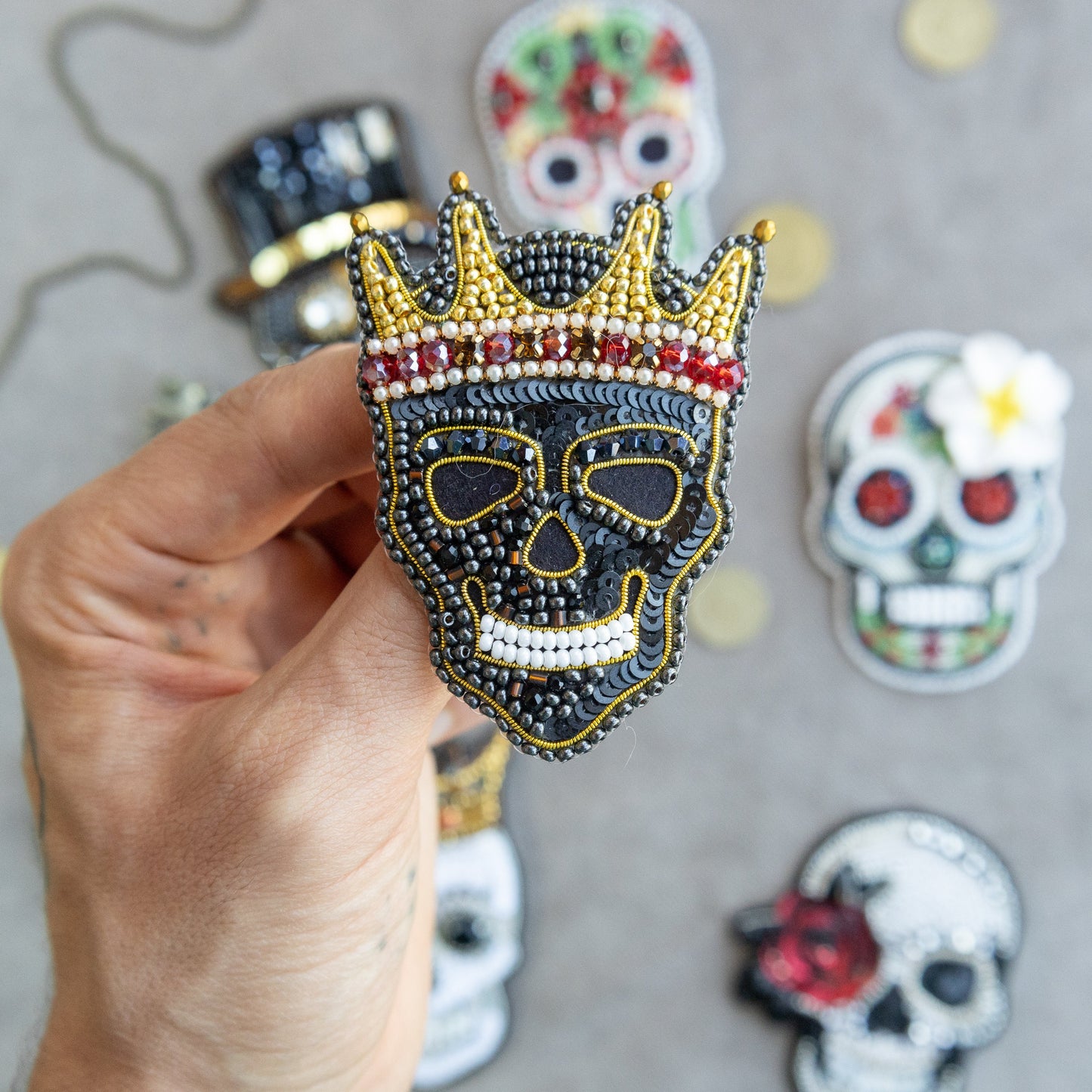 a hand holding a skull with a crown on it