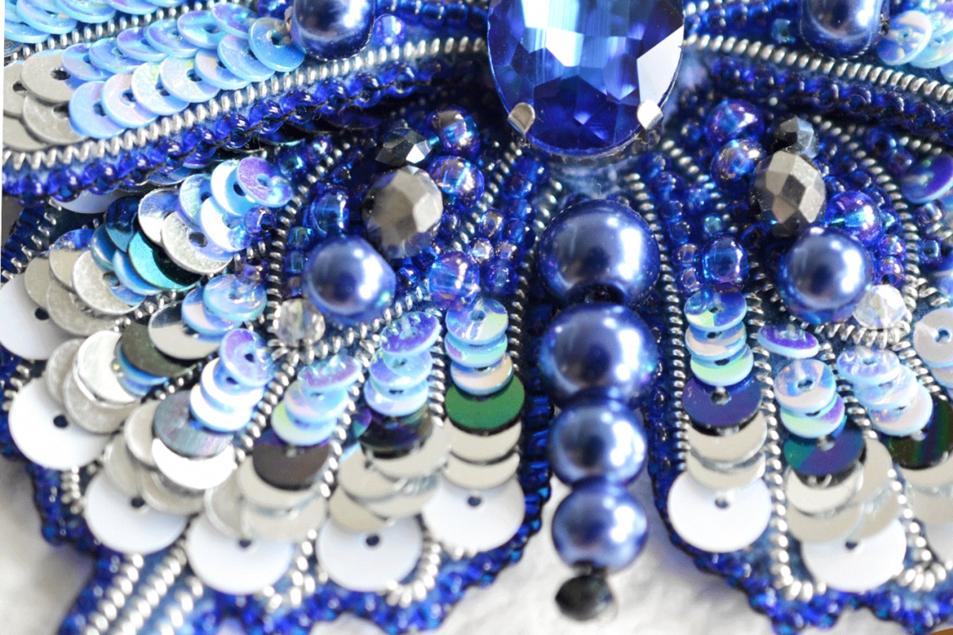 a close up of a blue and white brooch