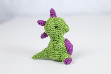 a crocheted green and purple stuffed animal