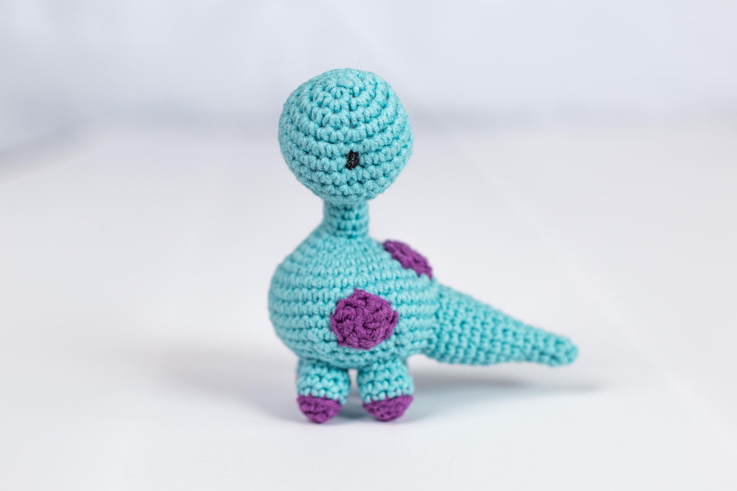 a crocheted blue bird with a flower on its chest