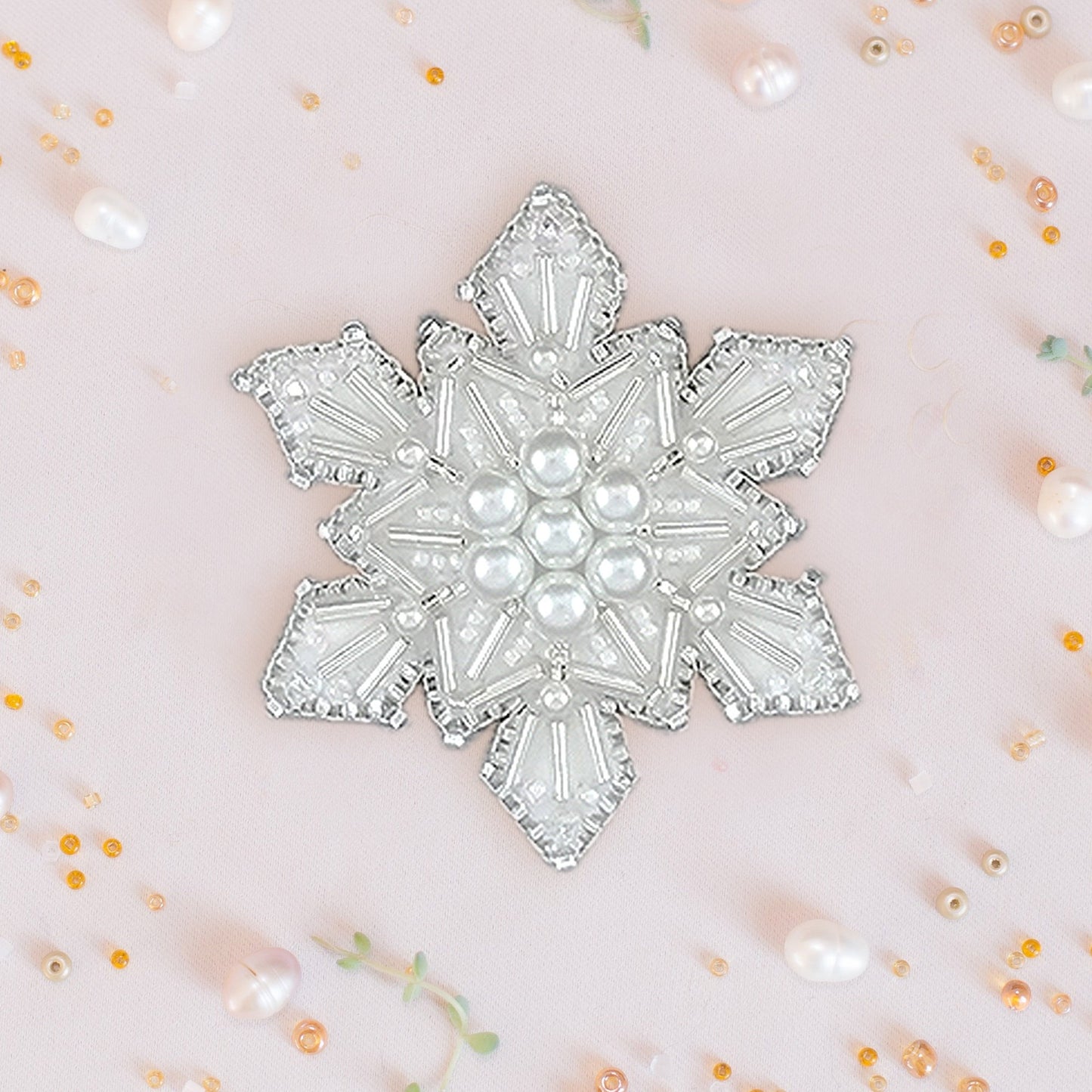 a white brooch with pearls on it