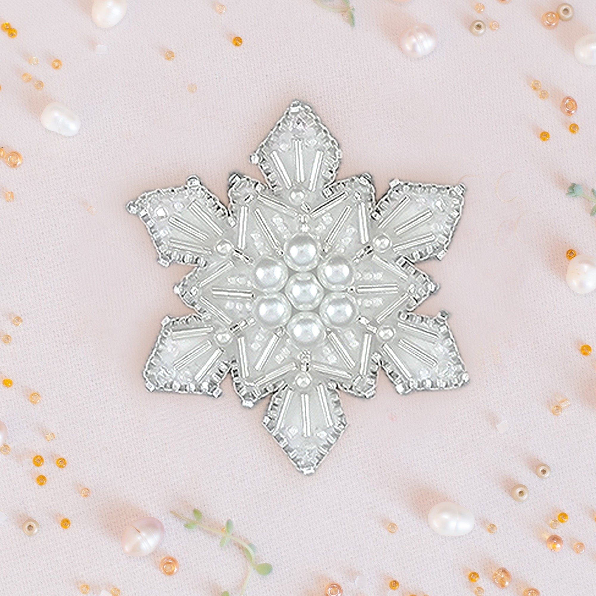 a white brooch with pearls on it