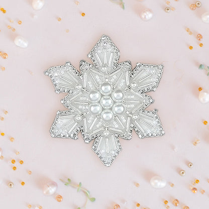 a white brooch with pearls on it