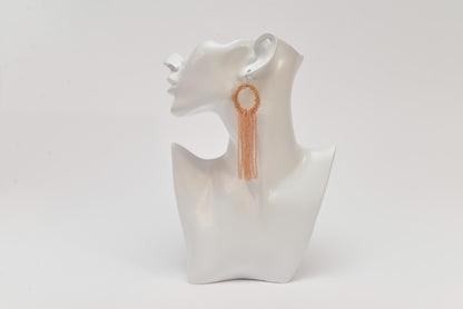 a white mannequin with a pair of earrings on it