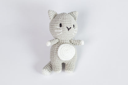 a crocheted cat sitting on a white surface