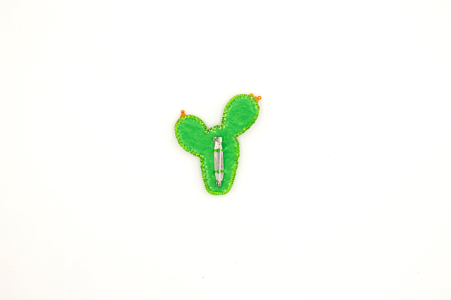 a green cactus pin sitting on top of a white surface
