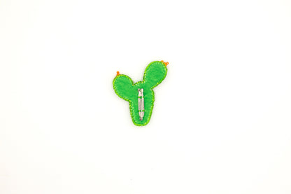a green cactus pin sitting on top of a white surface