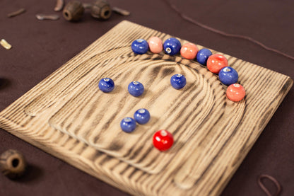 a wooden board with a game of marbles on it