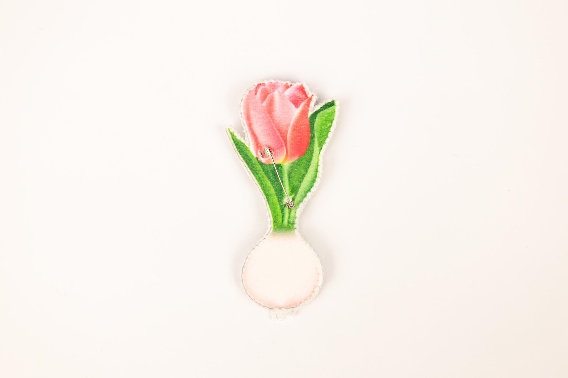 a pink tulip in a white vase on a white background