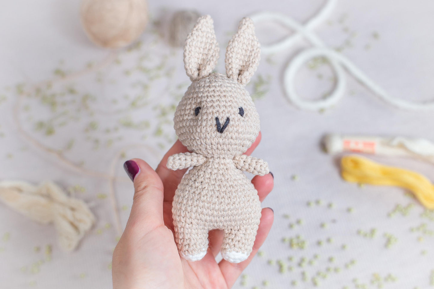a hand holding a small crocheted bunny