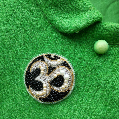 a close-up of a green fabric with a decorative brooch in the center.
