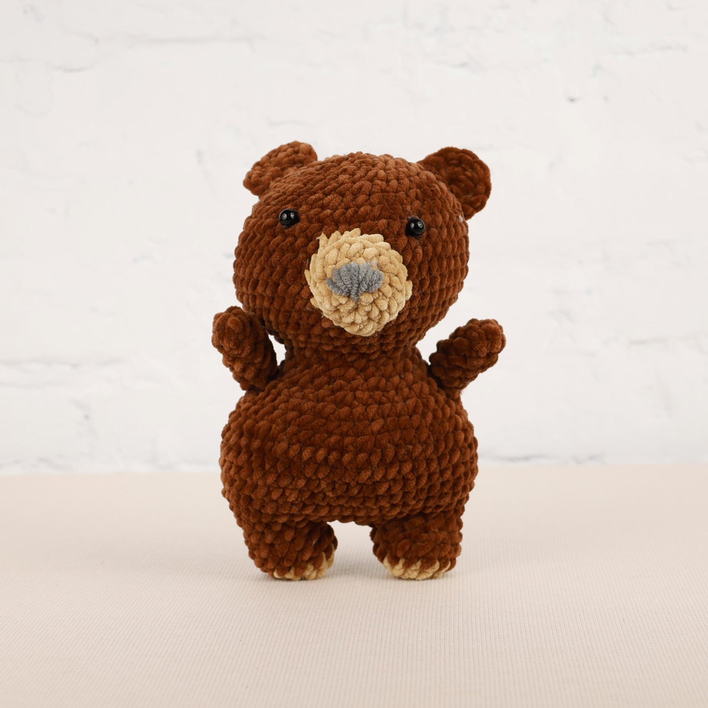 a crocheted brown teddy bear standing on its hind legs