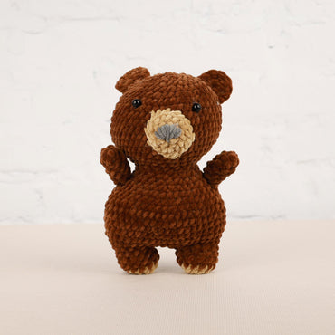 a crocheted brown teddy bear standing on its hind legs