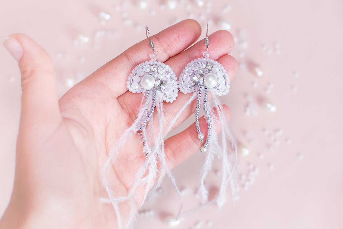 a person holding a pair of earrings in their hand