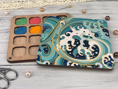 a box of beads next to a pair of scissors