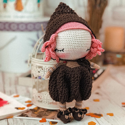 a crocheted doll sitting on top of a table