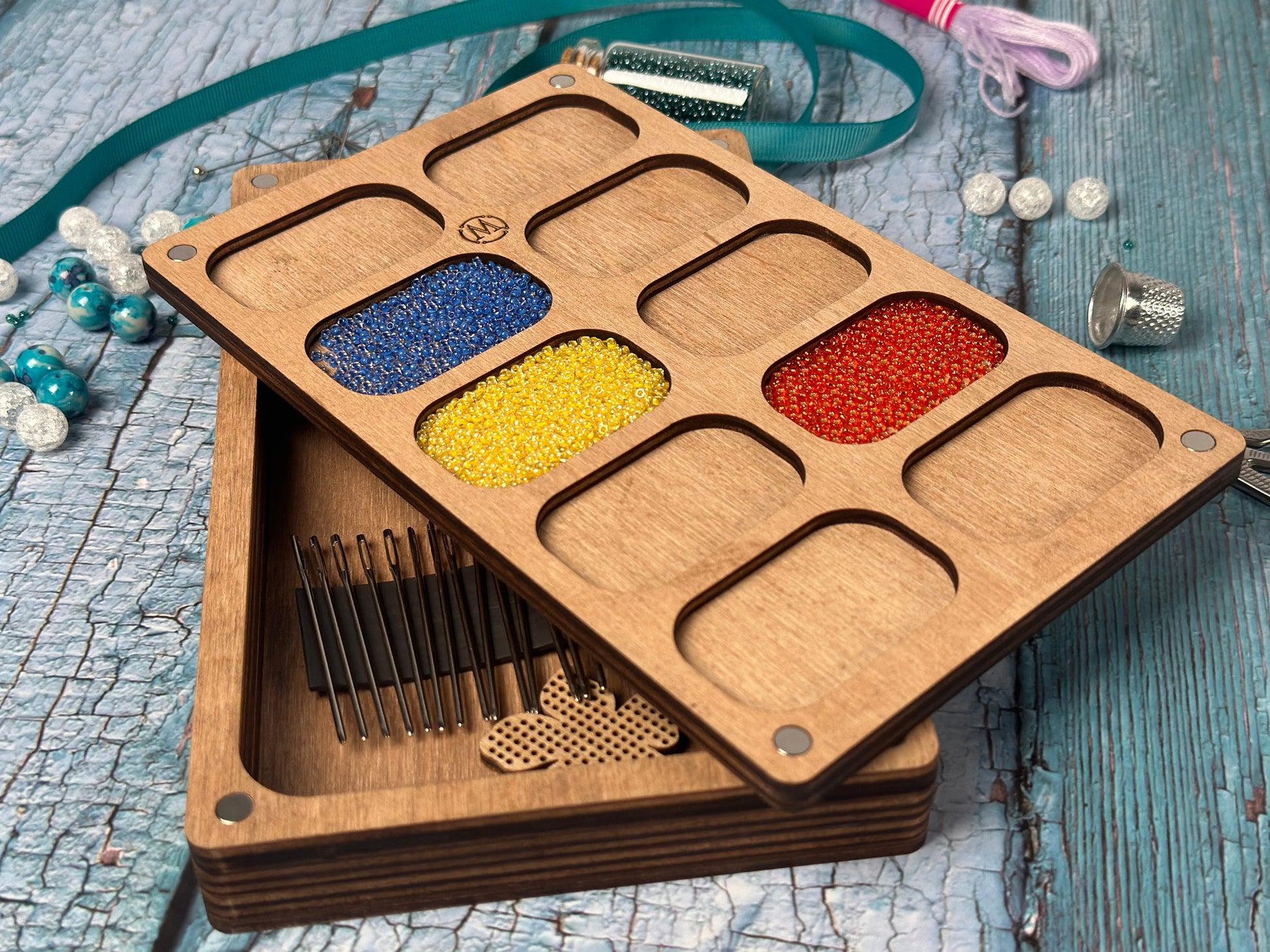 a wooden tray filled with different colored beads