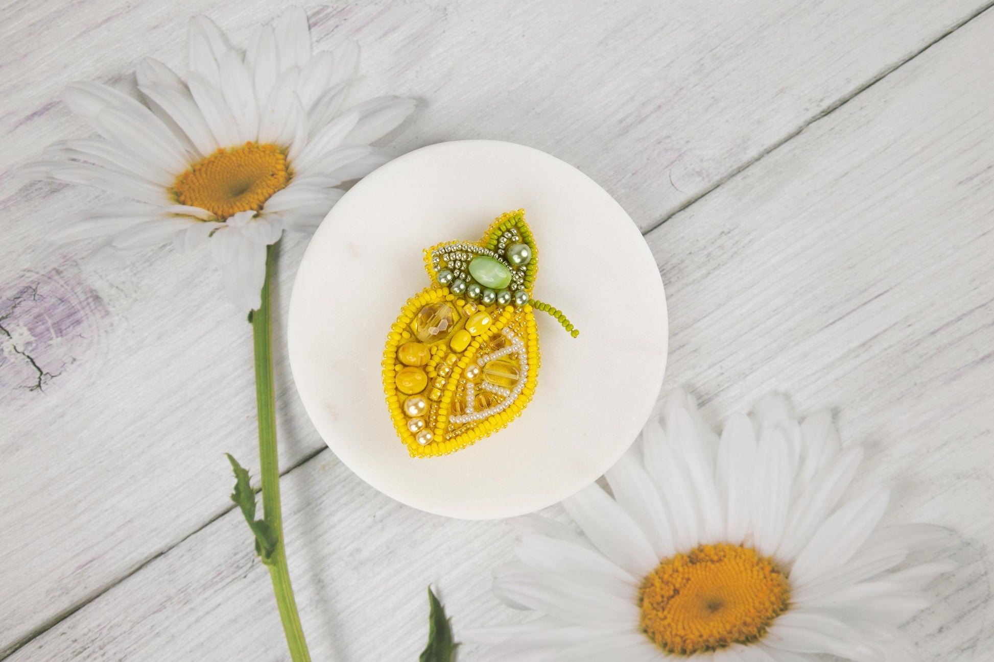 a white plate topped with a piece of fruit next to flowers
