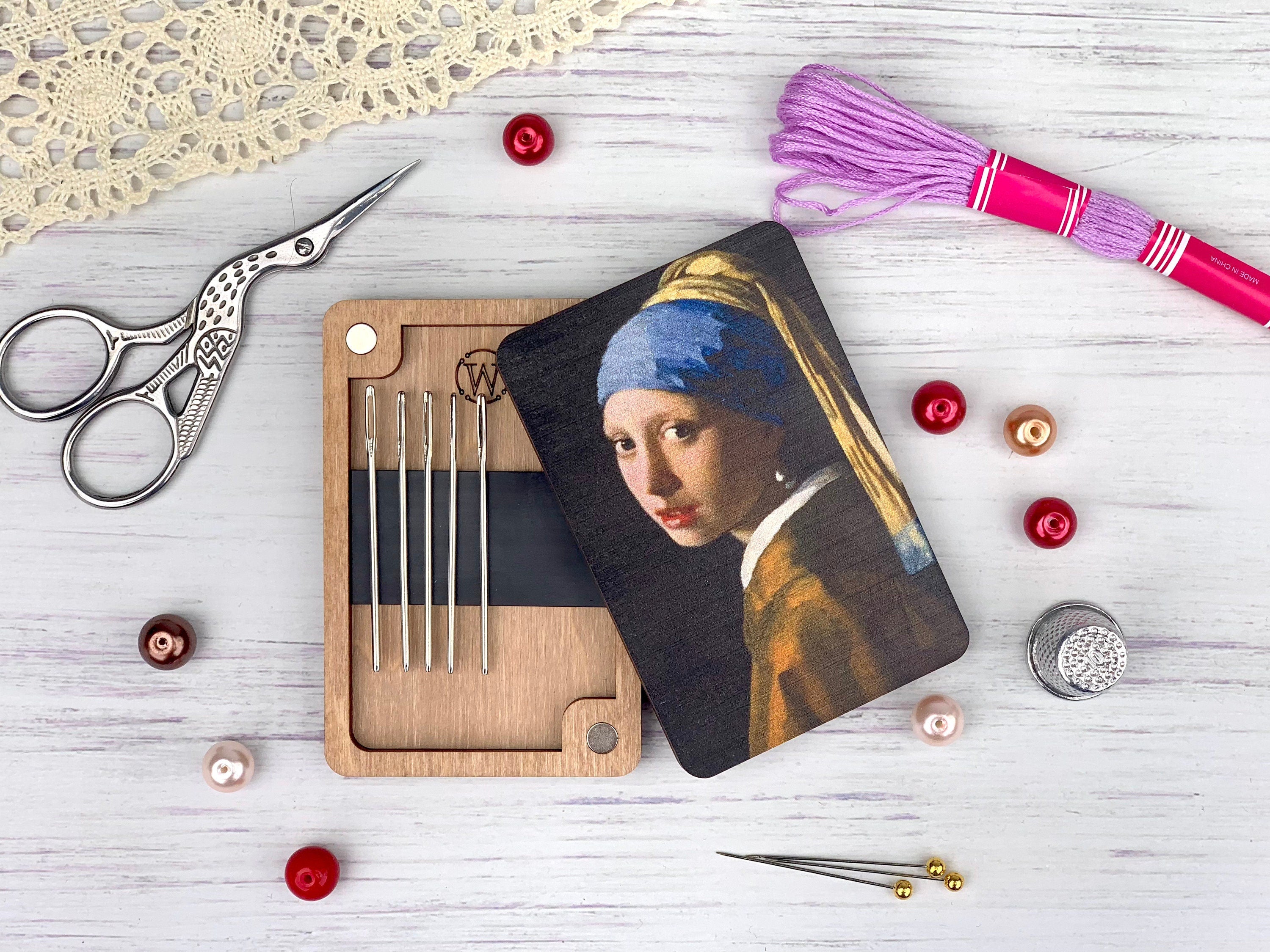 a picture of a girl with a pearl earring next to a pair of scissors