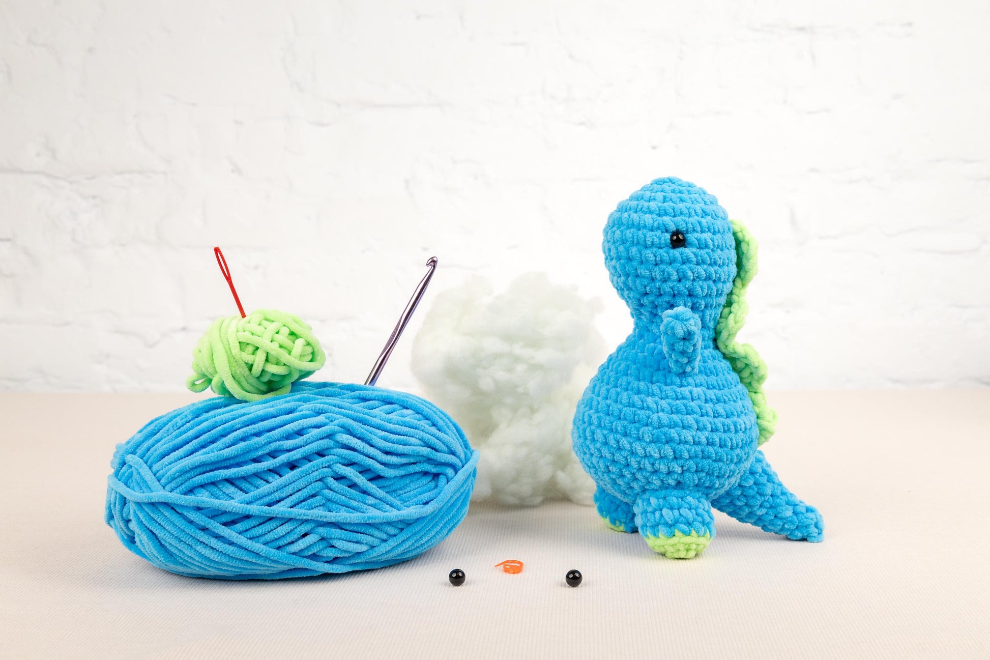 a ball of yarn next to a crocheted toy