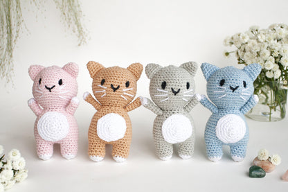 a group of crocheted cats standing next to each other