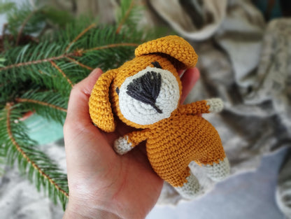 a hand holding a small crocheted stuffed animal