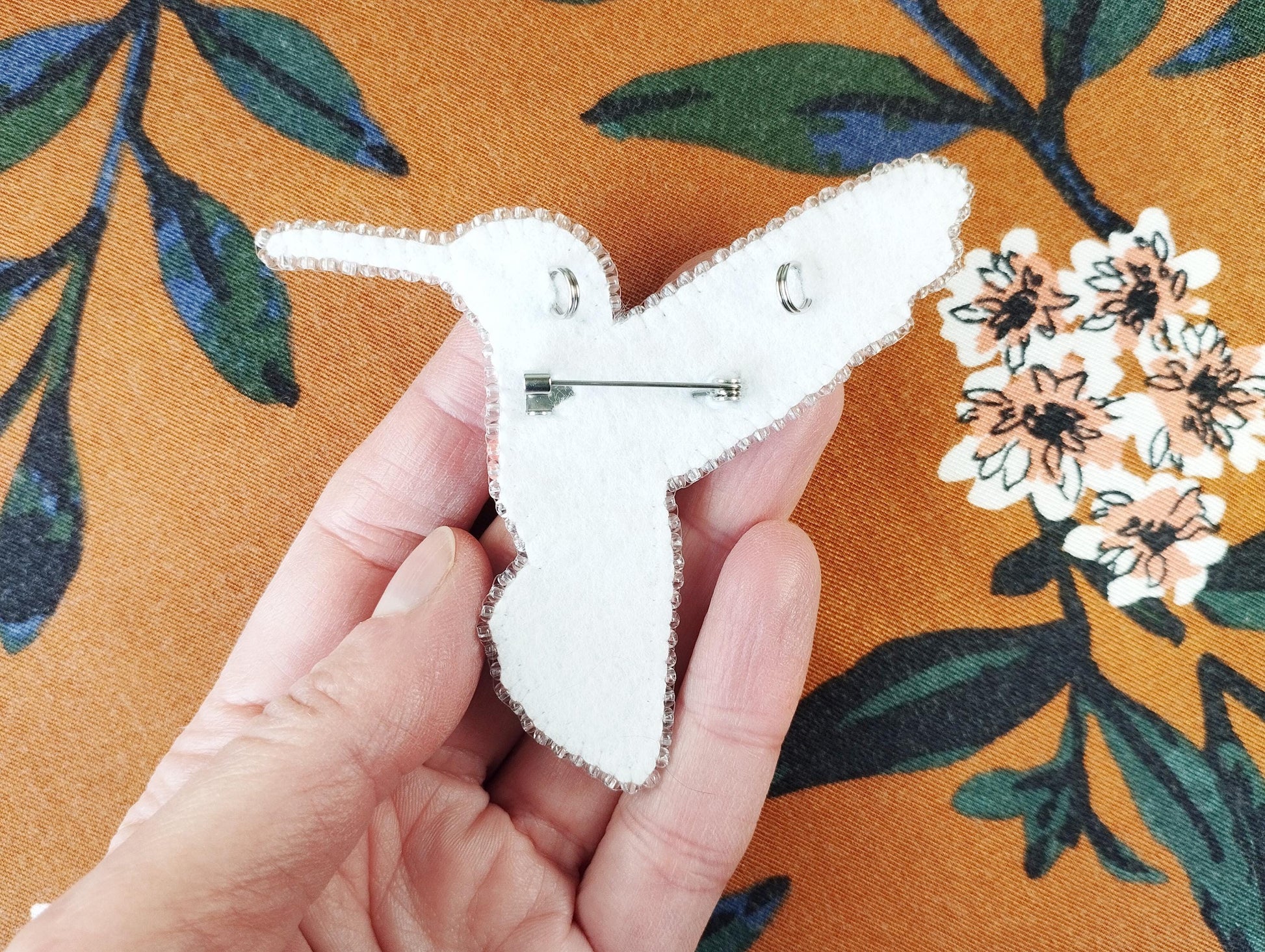 a person holding a pin with a flower on it