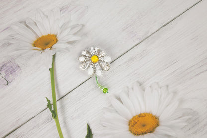 two daisies on a white wooden surface