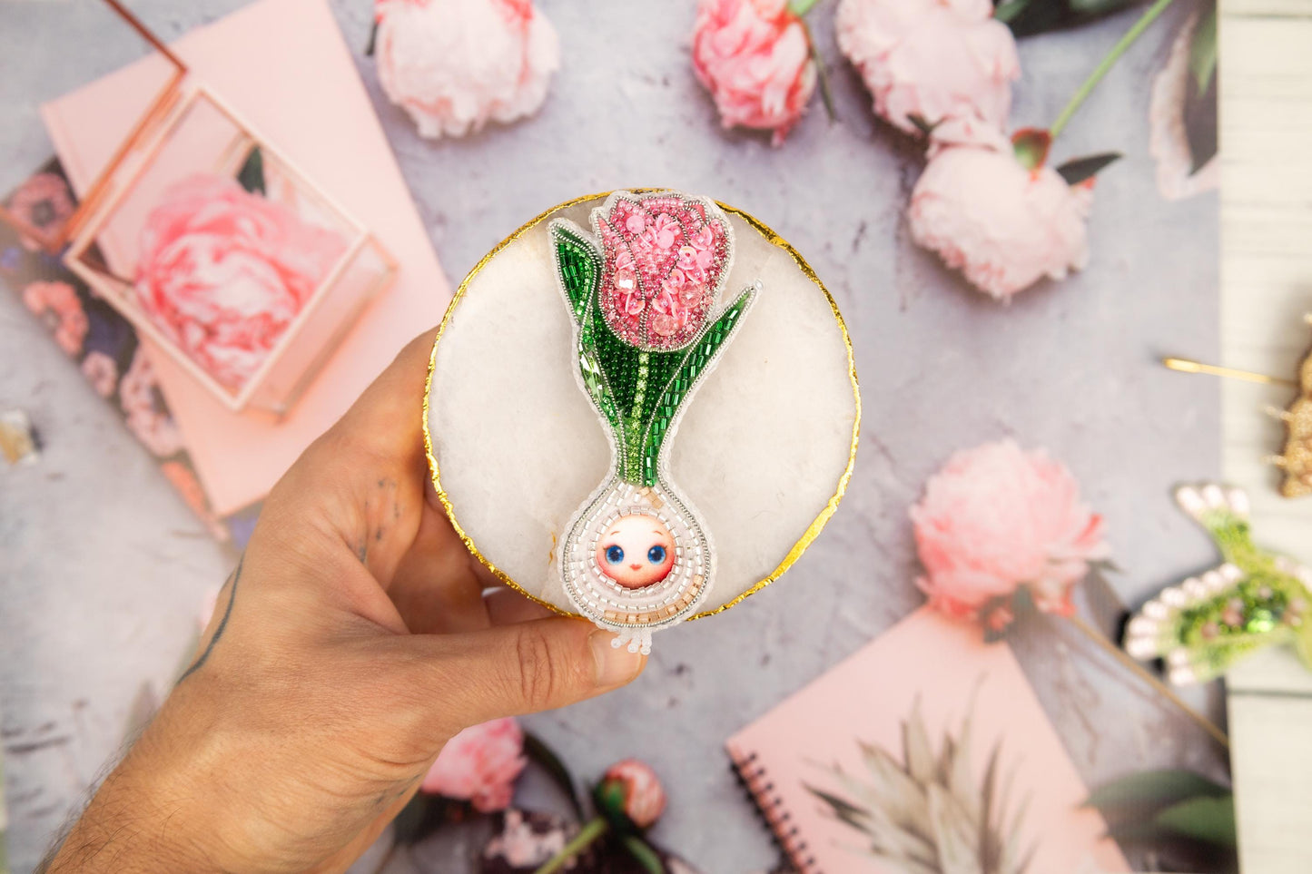 a person holding a small vase with a flower inside of it
