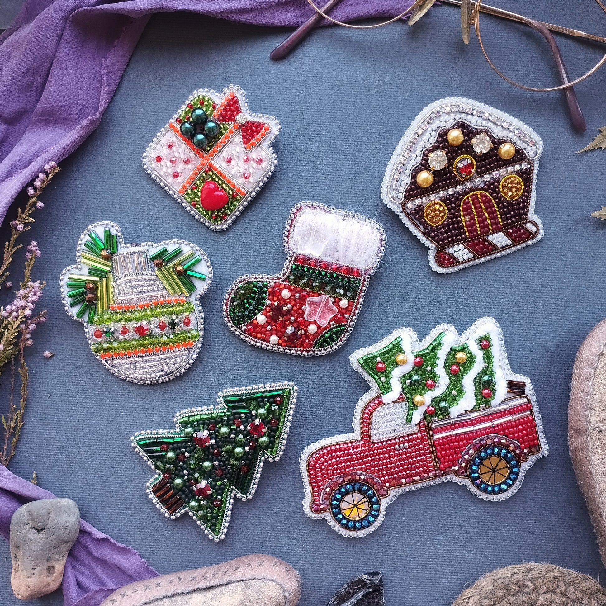 a collection of six decorative items, including a Christmas tree, a gingerbread house, a gift box, a stocking, a Christmas tree in a truck, and a snowman, all intricately crafted with beads and other embellishments.
