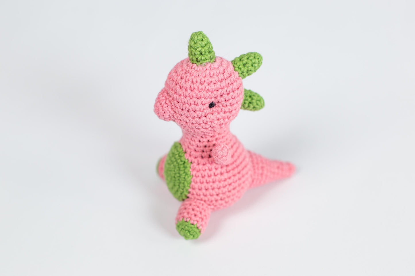 a crocheted pink and green stuffed animal