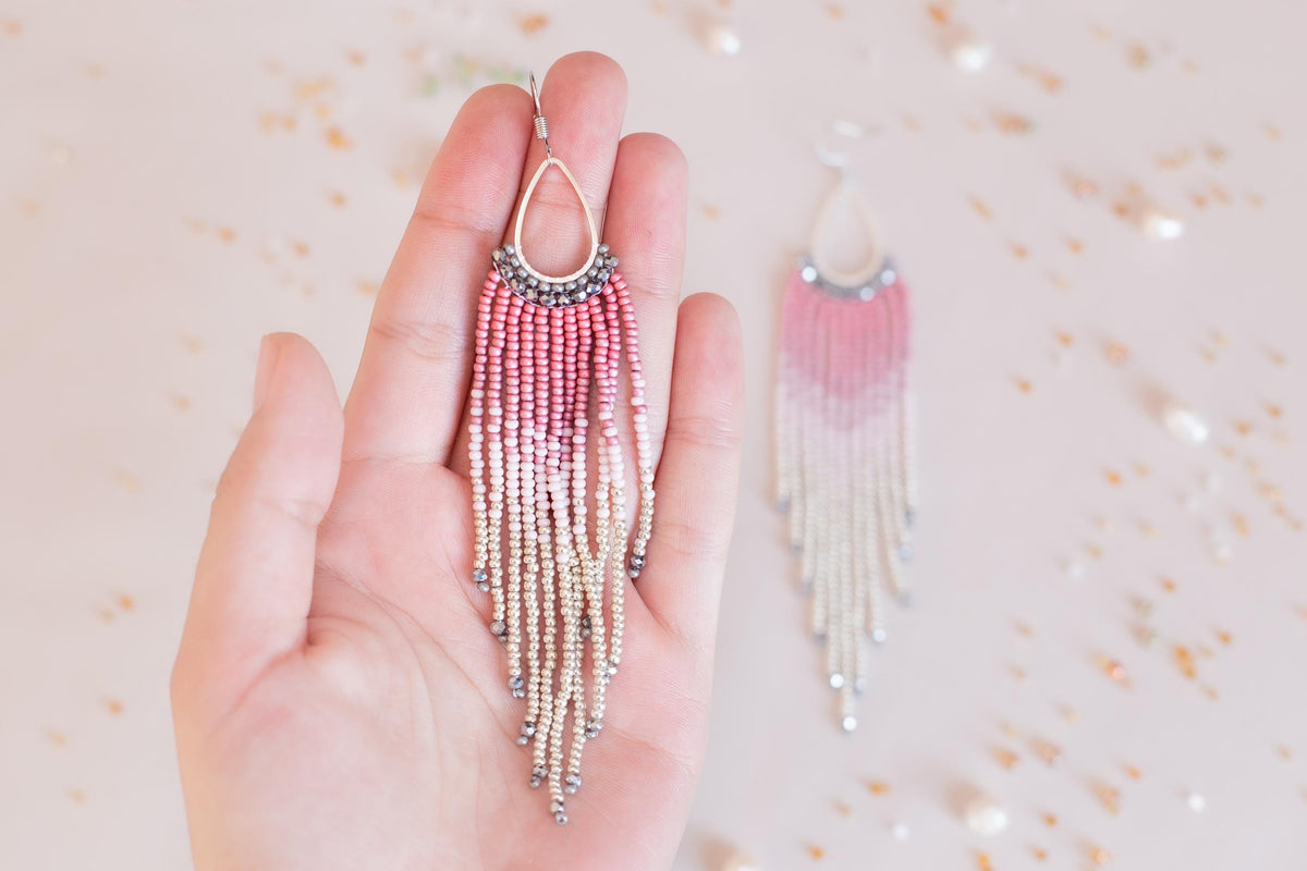 a person holding a pair of earrings in their hand