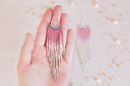a person holding a pair of earrings in their hand