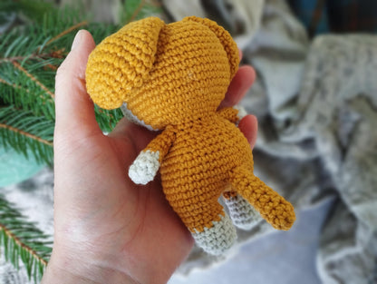 a hand holding a small crocheted stuffed animal