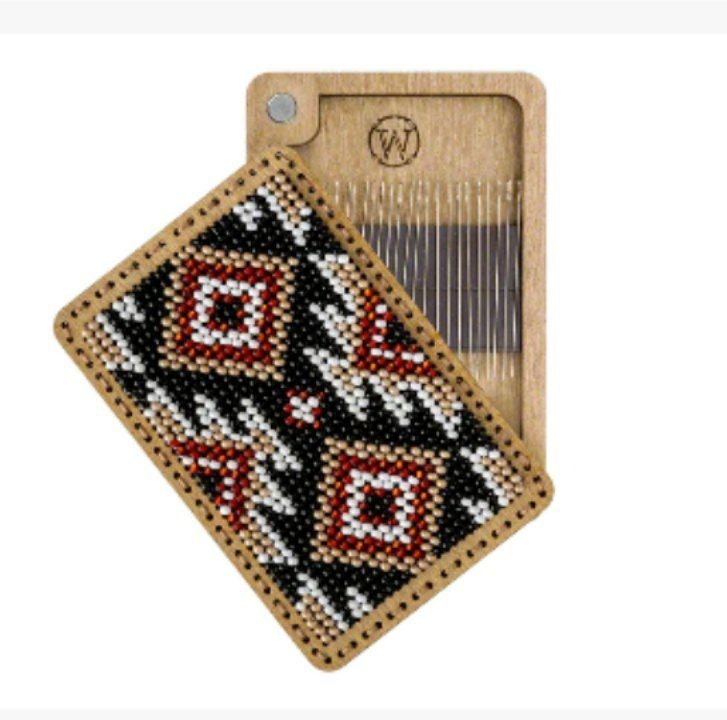 a wooden comb with a beaded pattern on it